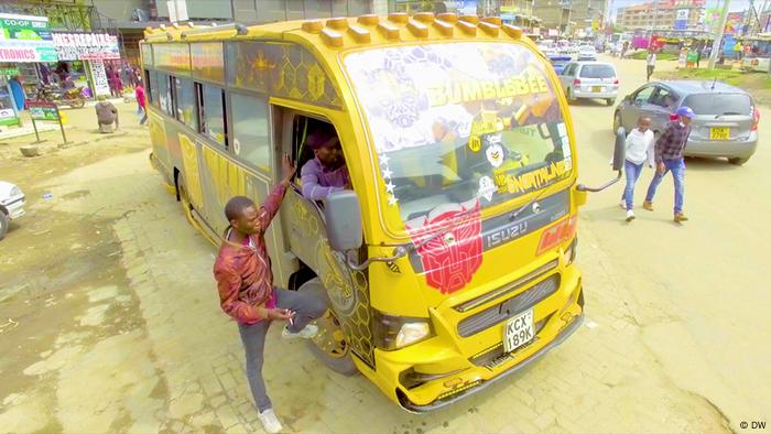 A man chatting with the driver of a Matatus bus in Kenya