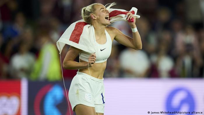 Die englische Nationalspielerin Chloe Kelly läuft mit der englischen Fahne über das Spielfeld und freut sich. (Manchester City FC)