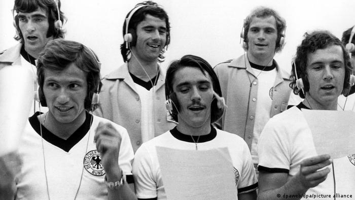 Deutsche Fußballer im Tonstudio, mit Kopfhörern und Textzetteln, 1973.