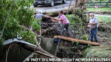 Tonya Smith, whose trailer was washed away by flooding, reaches for food from her mother Ollie Jean Johnson to give to Smith's father, Paul Johnson, as the trio used a rope to hang on over a swollen Grapevine Creek in Perry County, Kentucky, U.S. July 28, 2022. Matt Stone/USA Today Network via REUTERS NO RESALES. NO ARCHIVES. MANDATORY CREDIT
