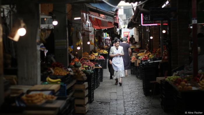 A woman walkes down an alley at Kutaisi's market.