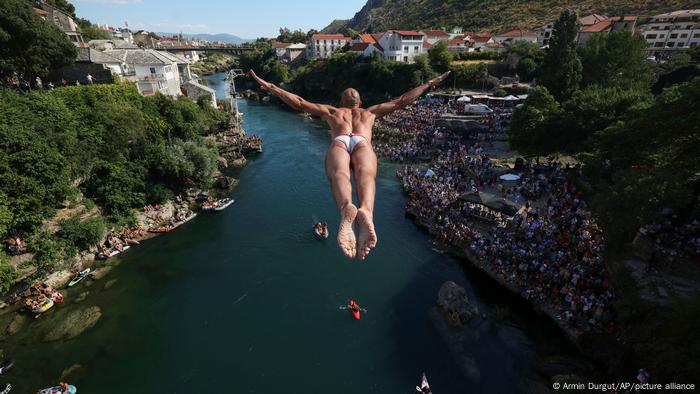 Un hombre se lanza desde el Puente Viejo de Mostar. Saltar desde esta construcción es una tradición centenaria en Bosnia. Por estos días se realiza la edición número 456 de la competición que ha logrado renombre internacional. El clavado se hace desde los 20 metros de altura y la zambullida termina en el río Neretva. Por estos días, un baño refrescante, pero solo recomendable para profesionales. 