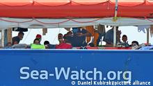 Migration über das zentrale Mittelmeer. Gerettete Menschen auf dem hinteren Deck der Sea Watch 3 warten auf die Aufnahme in Europa.
