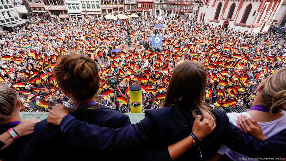 Deutsche Spieler blicken auf den Frankfurter Hauptplatz voller Deutschlandfahnen