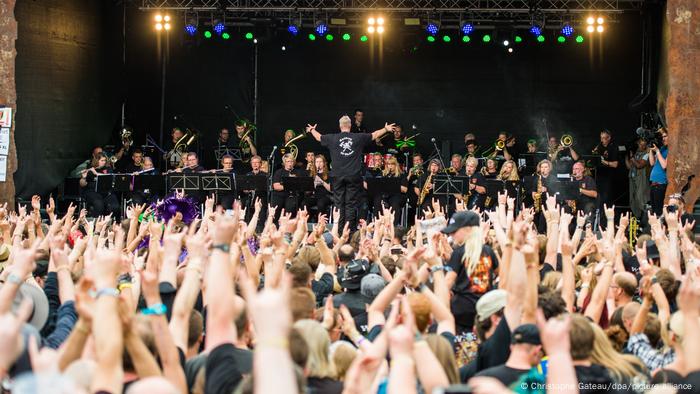 Wacken Open Air, orchestra on stage with a conductor, crod raises his hands Wacken Open Air, orchestra on stage with a conductor, crod raises his hands