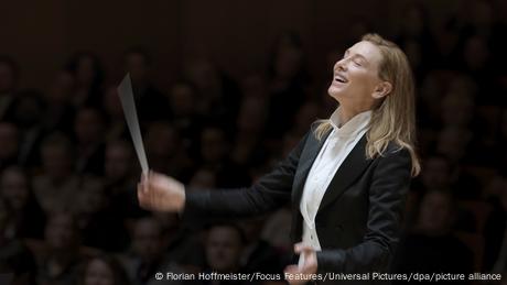 Cate Blanchett als Chefdirigentin Lydia Tár, sie dirigiert und lächelt dabei mit geschlossenen Augen.