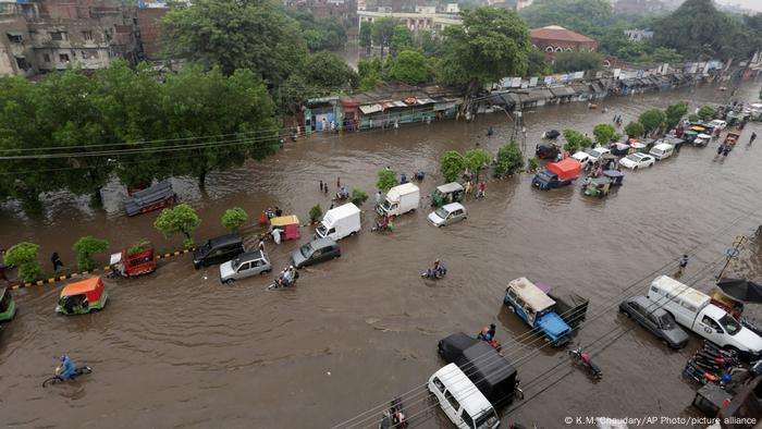 Vehicles drive through a flooded road following heavy rains in Lahore, Pakistan