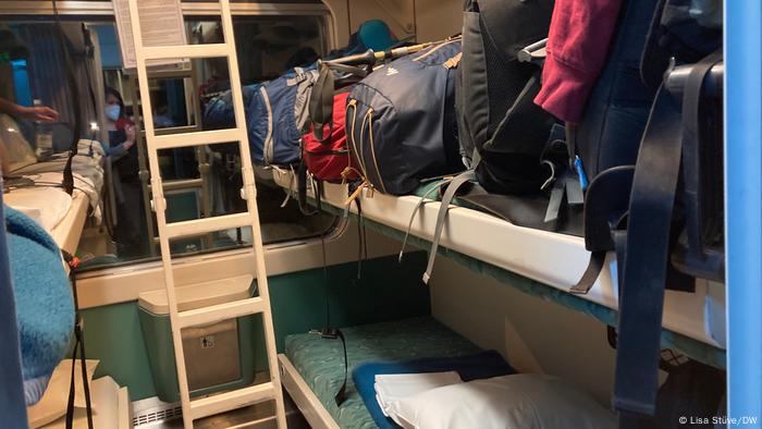 Sleeper wagon with bunk beds with lots of luggage on a night train.