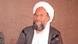Ayman al-Zawahiri aparece de barba e túnica, usa óculos, e olha para a câmera enquanto é fotografado. Ayman al-Zawahiri aparece de barba e túnica, usa óculos, e olha para a câmera enquanto é fotografado.