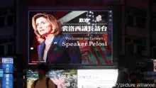 People walk past a billboard welcoming U.S. House Speaker Nancy Pelosi, in Taipei, Taiwan, Tuesday, Aug 2, 2022. U.S. House Speaker Nancy Pelosi was believed headed for Taiwan on Tuesday on a visit that could significantly escalate tensions with Beijing, which claims the self-ruled island as its own territory. (AP Photo/Chiang Ying-ying)