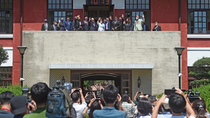 Nancy Pelosi y otros funcionarios saludan a los reporteros en el Parlamento de Taipei.