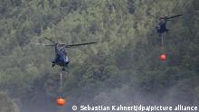 Ein Hubschrauber entnimmt mit einem Löschwasser-Außenlastbehälter Wasser aus der Elbe, um einen Waldbrand im Nationalpark Sächsische Schweiz zu löschen.