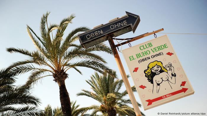 Palm tress with the sign advertising the Topless club on Mallorca 