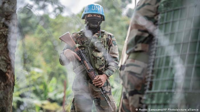 A UN MONUSCO soldier standing in front of a forest