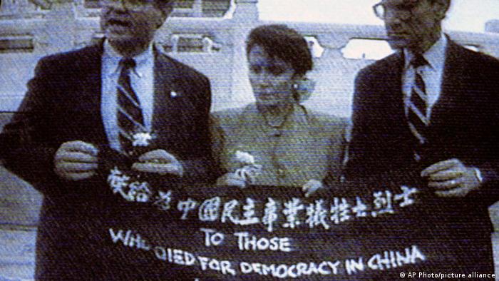  1991, Place Tienanmen : les députés américains Ben Jones, Nancy Pelosi et John Miller tiennent une banderole rendant hommage à ceux qui se sont morts pour la démocratie 