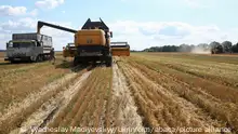 Kharkiv, Ukraine - July 30, 2022 - A combine harvester dumps grain crops into a truck as the harvest season is underway in the northern part of the region despite Russian shelling, Kharkiv Region, northeastern Ukraine. This photo cannot be distributed in the Russian Federation. Photo by Vyacheslav Madiyevskyy/Ukrinform/ABACAPRESS.COM