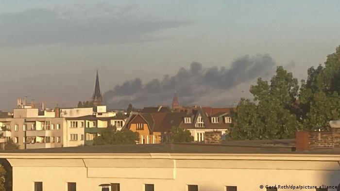 Дым от пожара над крышами домов в берлинском районе Груневальд