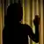 A silhouette of a woman near a curtain