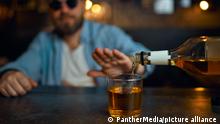 Man in sunglasses refuses to drink alcohol at the counter in bar. One male person resting in pub, human emotions, leisure activities, nightlife