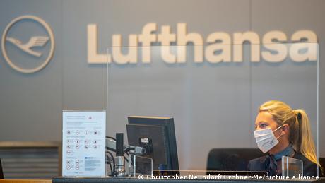 A Lufthansa ground staff employee sits at a check-in counter at the Münster/Osnabrück airport
