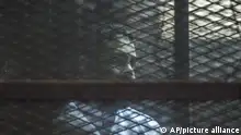 Prominent Egyptian activist Alaa Abd el-Fattah stands in a cage during a verdict hearing for 21 people over an unauthorized street protest in 2013, in a courtroom in Cairo, Egypt, Monday, Feb. 23, 2015. The court sentenced Abd el-Fattah, an icon of the country's 2011 revolt to five years in prison Monday, showing authorities' determination to continue to stifle dissent despite promises by its president to release wrongly jailed youths. Another defendant, Ahmed Abdel Rahman, was also given five years. Nineteen others were sentenced to three years. (AP Photo)