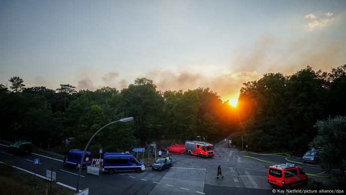 Puesta de sol en la escena, vehículos de bomberos en primer plano