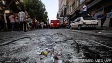 Shattered glass is scattered along a street following an Israeli air strike on Gaza City, on August 5, 2022. - The Israeli military said today it launched air strikes on Gaza, which were witnessed by Palestinians in central Gaza City. (Photo by Mohammed ABED / AFP)