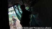 Ukrainian soldier Vyacheslav Timohovich with the Dnipro-1 regiment stands under a tent at an outpost near Sloviansk, Donetsk region, eastern Ukraine, Friday, Aug. 5, 2022. As heavy ground fighting continues on the front line only miles from Sloviansk, members of the Dnipro-1 regiment are fortifying their positions around the city which has experienced a period of relative calm in recent days with the last Russian strike occurring on July 30. (AP Photo/David Goldman)