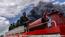 Firefighters move in a truck inside the Matanzas supertanker base to douse a fire that started during a thunderstorm, in Matanzas, Cuba, Sunday, Aug. 7, 2022. Cuban authorities say lightning struck a crude oil storage tank at the base, sparking a fire that sparked four explosions that injured more than 121 people, one person dead and 17 missing. (AP Photo/Ramon Espinosa)