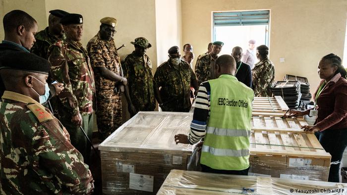 Tallying officers of the Independent Electoral and Boundaries Commission (IEBC) start opening the wrapping of ballot papers in front of police officers.