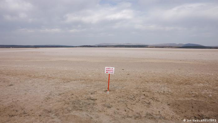 Tierra seca después de que el agua haya desaparecido del lago, un cartel dice anillamiento