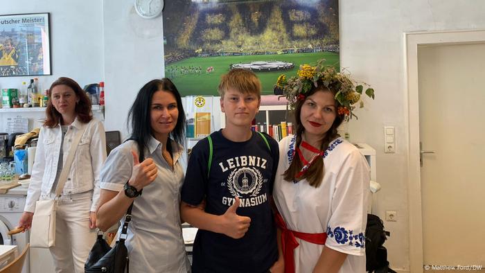 Refugiații ucraineni Anna, Vlad și Nadega la o galerie foto din Dortmund