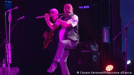 Ian Anderson spielt Querflöte und steht dabei auf einem Bein.