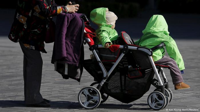 中国鼓励生育二孩，但现实问题仍困扰女性，图为一位老年人带著两个小孩出门（资料照）