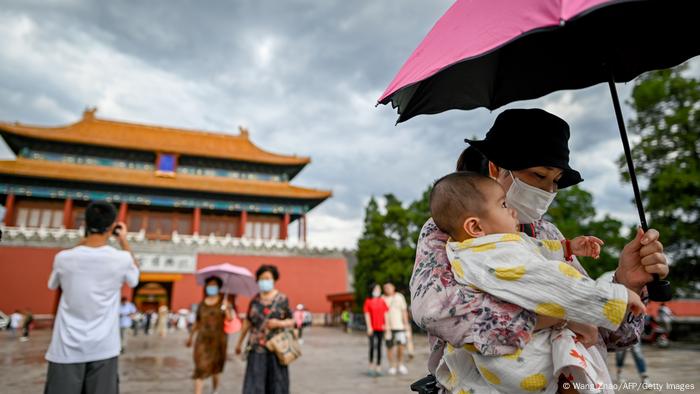 中国的生育成本是否过高，成为智库关心的话题，图为2020年一位中国女性抱著小孩在北京紫禁城外（资料照）