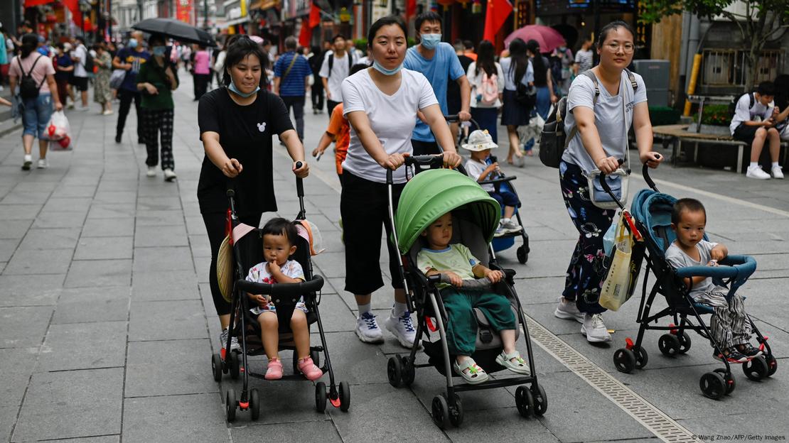 Mães chinesas empurrando carrinhos de bebê com seus filhos