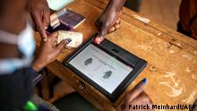 An election official verifies a voter's information on the Kenya Integrated Electoral Management System (KIEMS) at the Gatina primary school polling station during Kenya´s general election in Kawangware, Nairobi on August 9, 2022. (Photo by Patrick Meinhardt / AFP)