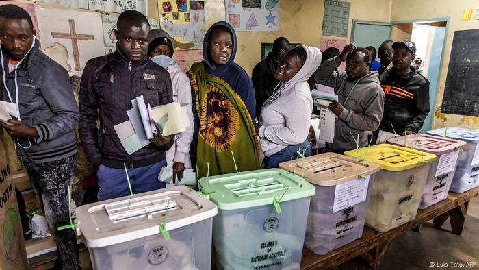 A group of Kenyan voters queue while waiting to vote.