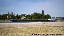 08.08.2022, Baden-Württemberg, Altlußheim: Ein Schiff fährt auf dem Rhein mit Niedrigwasser. Im Hintergrund ist der Dom zu Speyer in Rheinland-Pfalz zu sehen. (Zu dpa «Kein Regen in Sicht - Experten: außergewöhnliche Lage an Gewässern») Foto: René Priebe/PR-Video/dpa +++ dpa-Bildfunk +++