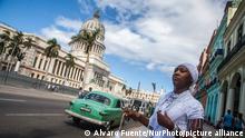 A woman from YorubaÂ_s religion dressed in white for overtake the purity waiting a taxi near the National Capitol Building in Havana, Cuba, on 23 November 2016. (Photo by Alvaro Fuente/NurPhoto)