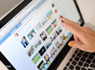 A hand pointing at a monitor showing rows of pictures