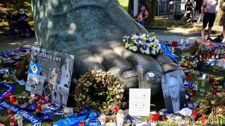 Bronze replica of Uwe Seeler's right foot adorned by flowers and other tokens of remembrance