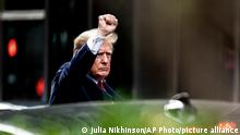 Donald Trump raising his fist before he gets into a car