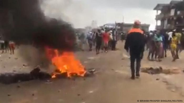 In this screen grab obtained from a social media video, smoke rises from a fire as people gather on the streets amid anti-government protests