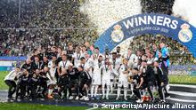 Real Madrid players celebrate with the trophy after winning the UEFA Super Cup final soccer match between Real Madrid and Eintracht Frankfurt at Helsinki's Olympic Stadium, Finland, Wednesday, Aug. 10, 2022. (AP Photo/Sergei Grits)