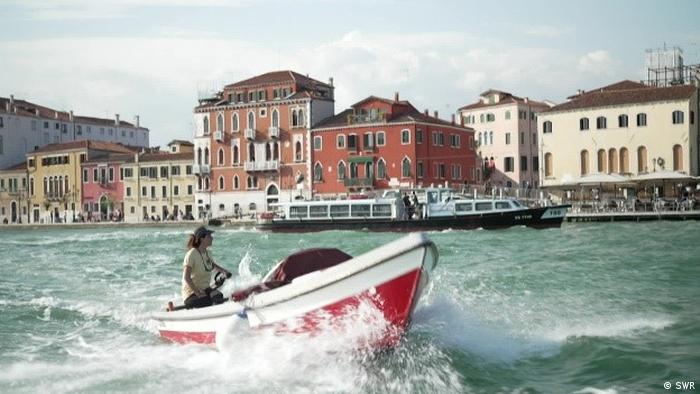 Una persona viaja en lancha por un canal de Venecia.