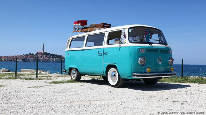 Un vieux camping-car VW bleu garé sur le front de mer