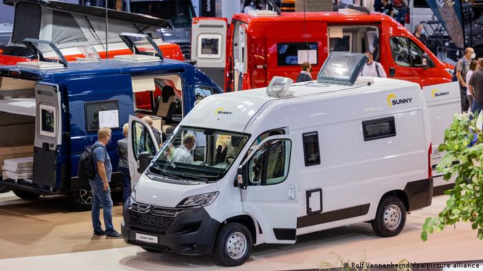 People looking at camper vans at a trade show 