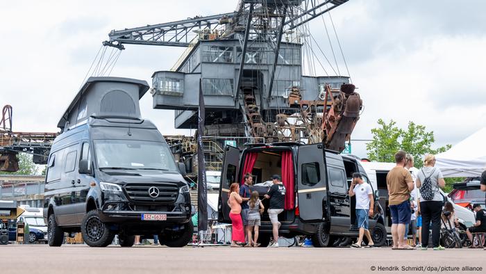 Reisemobile stehen unter einem Tagebau-Bagger in der Veranstaltungsarena Ferropolis in Gräfenhainichen