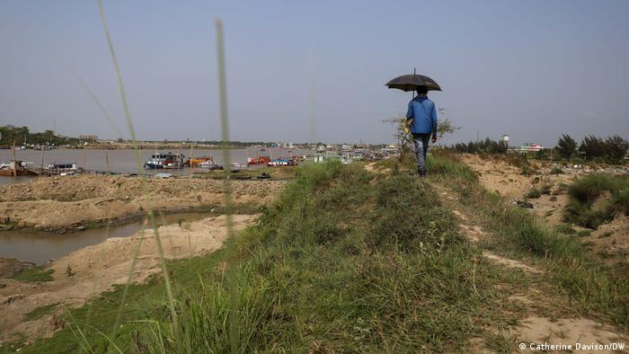 A man walks along part of an 11km long floodbank in Mongla